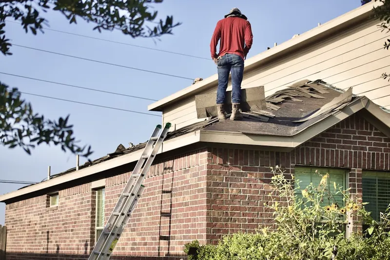 Professional roofer working on a residential roof in Cadillac Drive